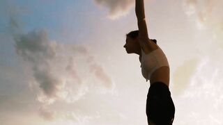 A Woman Stretching In A Scenic Sunset