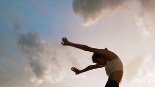 A Woman Stretching In A Scenic Sunset