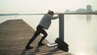 Person Doing Stretching Exercises On A Dock