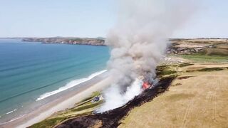 UK heatwave: Drone footage shows huge gorse fire at Welsh beach as temperatures soar