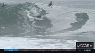 Onlookers gather at The Wedge in Newport Beach as high-powered swells hit SoCal