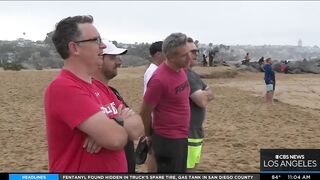 Onlookers gather at The Wedge in Newport Beach as high-powered swells hit SoCal