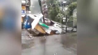 Buildings and cars are swept away with a huge stream of flood in Himachal Pradesh, India