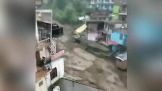 Buildings and cars are swept away with a huge stream of flood in Himachal Pradesh, India