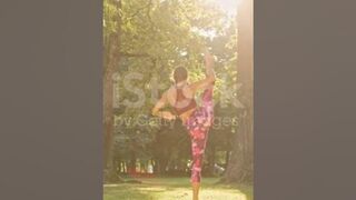 Mujer joven flexible practicando divisiones de pie en un parque soleado #yogamusic #shorts