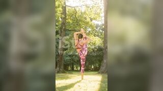 Mujer joven flexible practicando divisiones de pie en un parque soleado #yogamusic #shorts