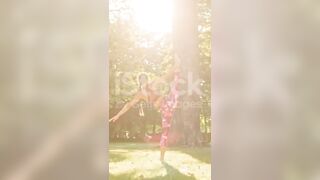 Mujer joven flexible practicando divisiones de pie en un parque soleado #yogamusic #shorts