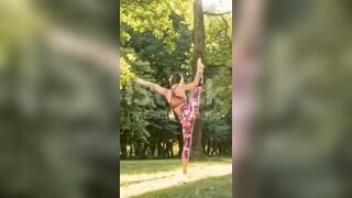 Mujer joven flexible practicando divisiones de pie en un parque soleado #yogamusic #shorts