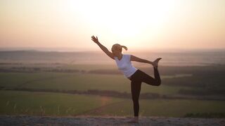 Silhouette of Unrecognizable Flexible Yogi Woman Practicing Yoga Balancing on One Leg Stretching